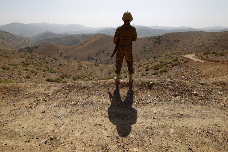 A soldier in North Waziristan, Pakistan, stands guard along the border fence with Afghanistan, Oct. 18 (CNS photo/Caren Firouz, Reuters).