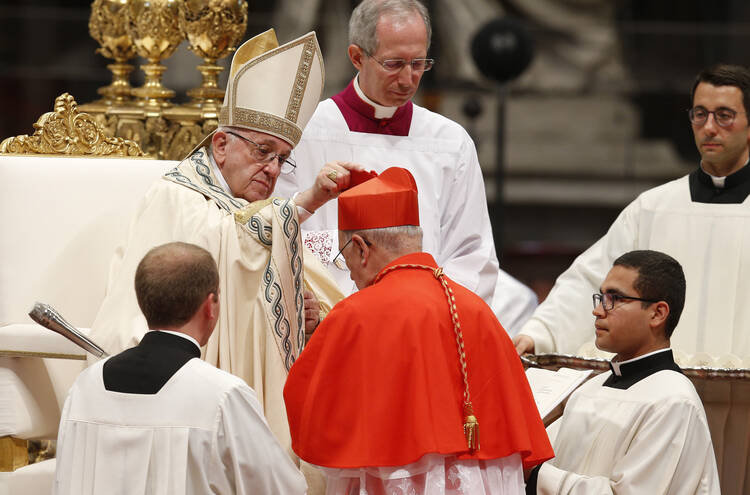 Pope Francis places a red biretta on new Cardinal Pedro Barreto of Huancayo, Peru, during a consistory to create 14 new cardinals in St. Peter's Basilica at the Vatican June 28. (CNS photo/Paul Haring)