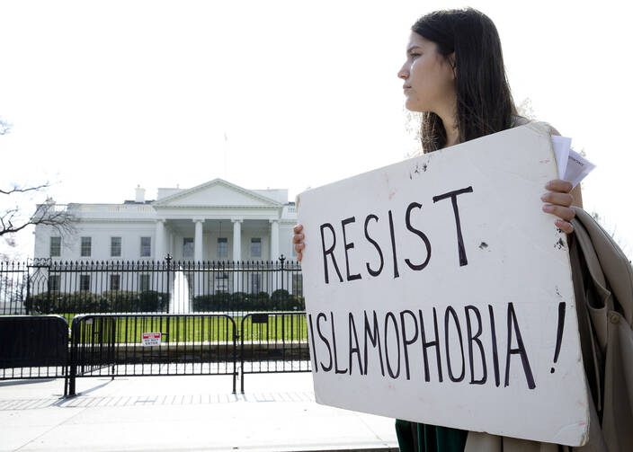 A peace activist holds a sign saying "Resist Islamophobia!" during a prayer service in early March outside the White House in Washington. (CNS photo/Tyler Orsburn)