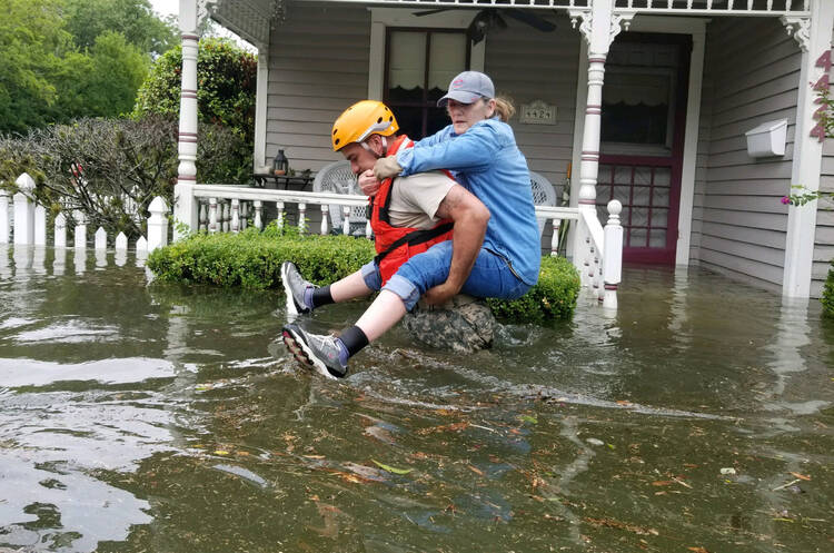 A Texas National Guard soldier carries a woman on his back Aug. 27 during rescue operations around Houston, Tex (CNS photo/courtesy Texas Military Department).