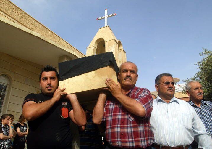 Iraqi men carry the coffin of a Christian man, who was killed by unknown gunmen, during his funeral in 2011 in Kirkuk (CNS photo/Khalil Al-A'nei, EPA).