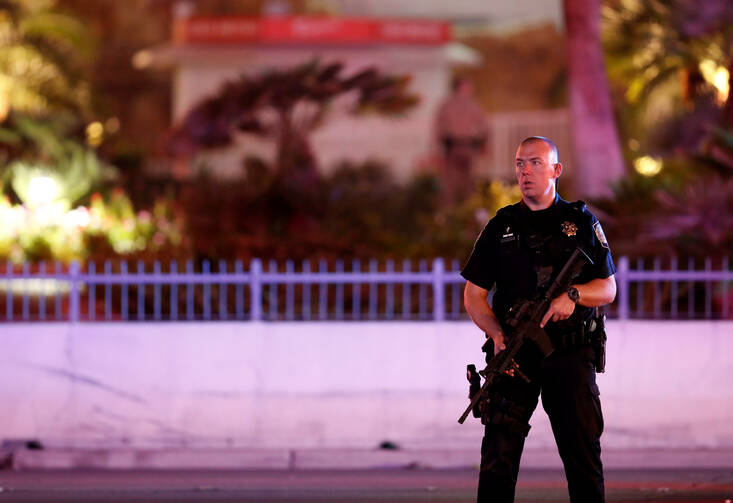 A police officer stands in front of the Tropicana hotel-casino in Las Vegas Oct. 2 after a mass shooting at a music festival. A gunman perched on the 32nd floor of a hotel unleashed a shower of bullets late Oct. 1 on an outdoor country music festival below, killing more than 50 people and wounding hundreds, making it the worst mass shooting in modern U.S. history (CNS photo/Steve Marcus, Las Vegas Suns). 
