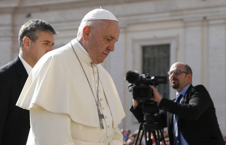  Pope Francis walks past a video journalist during his general audience in St. Peter's Square at the Vatican April 25. (CNS photo/Paul Haring) 