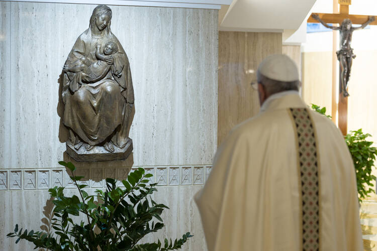 Pope Francis prays before a sculpture of Mary and the Christ Child at the end of Mass May 7, 2020, in the chapel of his Vatican residence, the Domus Sanctae Marthae. (CNS photo/Vatican Media)