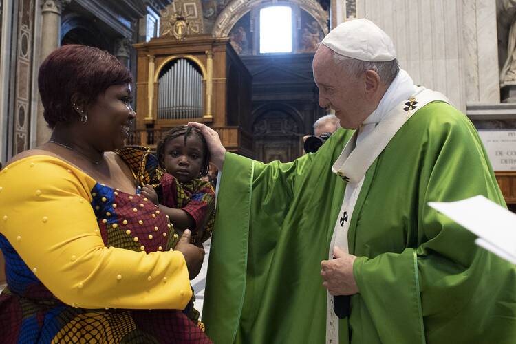  Pope Francis greets a woman and child during a July 8, 2019, Mass in St. Peter's Basilica at the Vatican commemorating the sixth anniversary of his visit to the southern Mediterranean island of Lampedusa. (CNS Photo/Vatican Media)