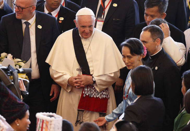 Pope Francis wears a gift as he arrives with Aung San Suu Kyi, state counselor and foreign minister of Myanmar, for a meeting with government authorities, members of civil society and the diplomatic corps at the Myanmar International Convention Center in Naypyitaw, Myanmar, Nov. 28. (CNS photo/Paul Haring)