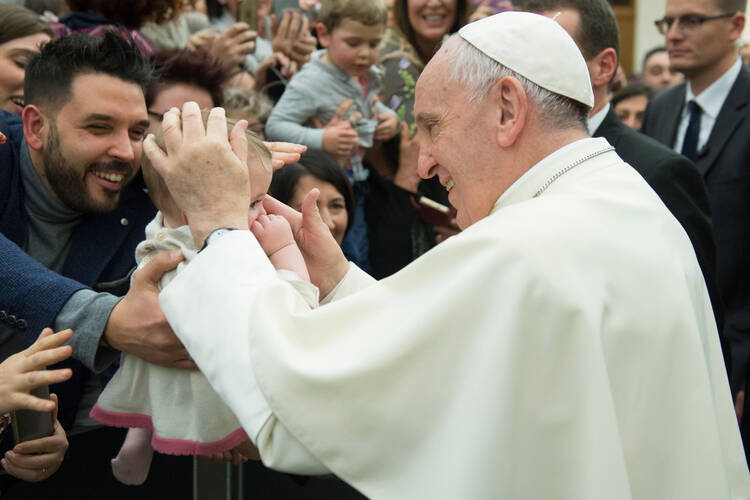 Pope Francis greets a baby during an audience with Italian nurses in Paul VI hall at the Vatican March 3. (CNS photo/Vatican Media)