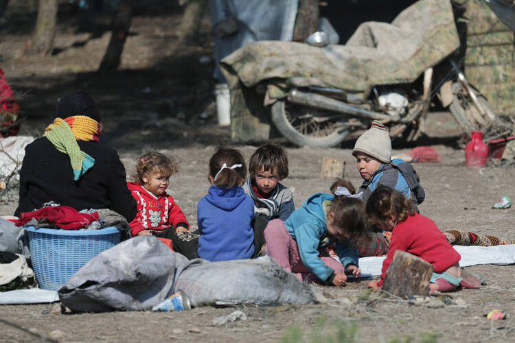 Syrian children sit on the ground at a makeshift camp in Qatmah Feb. 17, 2020. The Sept. 27 celebration of World Day of Migrants and Refugees will emphasize people displaced within their own countries. (CNS photo/Khalil Ashawi, Reuters)