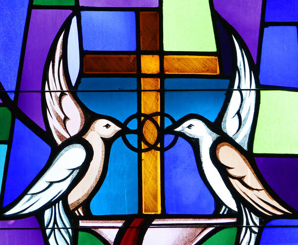 Doves and interlocking wedding bands symbolizing the sacrament of marriage are depicted in a stained-glass window at Sts. Cyril & Methodius Church in Deer Park, N.Y. 