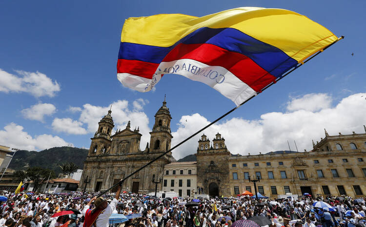 A man waves a Colombian flag in Bogota, Colombia, in this 2015 file photo (CNS photo/John Vizcaino, Reuters).