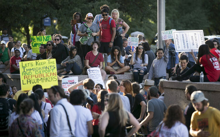 Protesters, who are against the Senate Bill 4 Sanctuary Cities ban, rally outside the Texas Department of Insurance building, where Gov. Greg Abbott has an office in Austin, Texas, on Monday, May 1, 2017. (Jay Janner/Austin American-Statesman via AP)