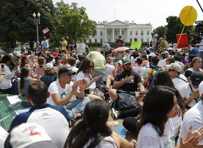 Demonstrators sit on the ground along Pennsylvania Ave. in front of the White House in Washington, on Saturday, April 29, 2017, during a demonstration and march. (AP Photo/Pablo Martinez Monsivais)