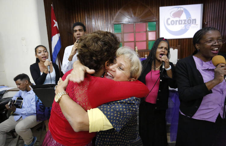 In this March 19, 2017 photo, people greet each other and sing as they attend Sunday worship at the William Carey Baptist Church in Havana, Cuba. (AP Photo/Desmond Boylan)