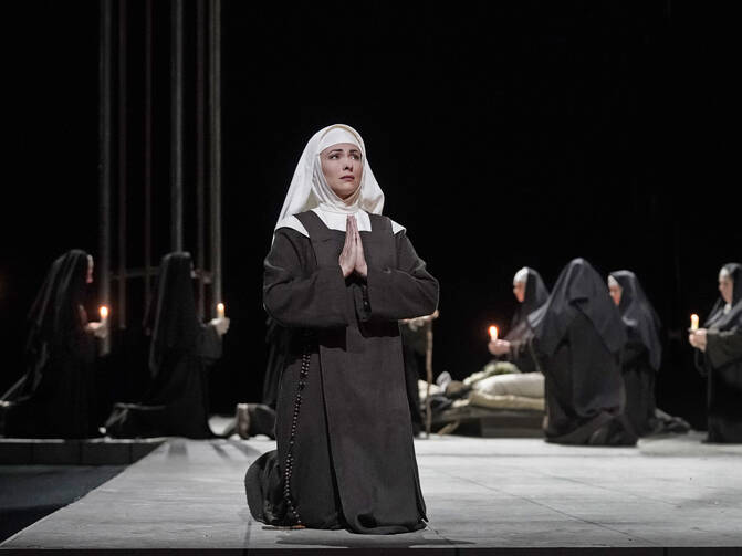 Nun kneeling on stage
