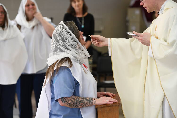 Erin Ratleff receives communion at DCI’s Easter mass, where she was confirmed (she had already been baptized and made her First Communion as a child). (Credit: Mark Bowen/Archdiocese Of Cincinnati)