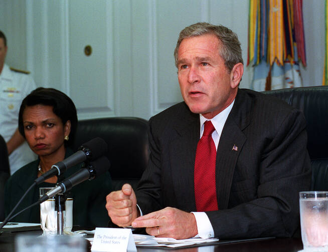 President George W. Bush addresses the media at the Pentagon on Sept. 17, 2001, following a meeting with his national security team and leaders of the National Guard and Reserve forces. Seated at the left is National Security Advisor Condoleezza Rice.