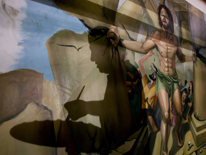 In this Monday, April 24, 2017 photo, the shadow of Coptic Christian Ayman William is reflected on a dome where he is painting a biblical scene of Samson, at Mar Girgis Church in Zawiya al-Hamra, in Cairo, Egypt. (AP Photo/Amr Nabil)