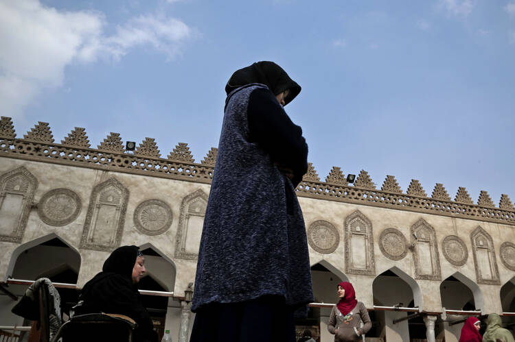 In this Feb. 20, 2017 file photo, an Indonesian al-Azhar university student, center, and an elderly Egyptian woman pray at al-Azhar Mosque, in Cairo, Egypt. (AP Photo/Nariman El-Mofty)