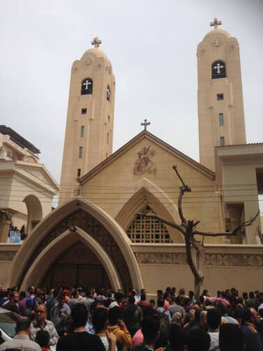 Relatives and onlookers gather outside a church after a bomb attack in the Nile Delta town of Tanta, Egypt, Sunday, April 9, 2017. The attack took place on Palm Sunday, the start of the Holy Week leading up to Easter, when the church in the Nile Delta town of Tanta was packed with worshippers. (AP Photo/Ahmed Hatem)