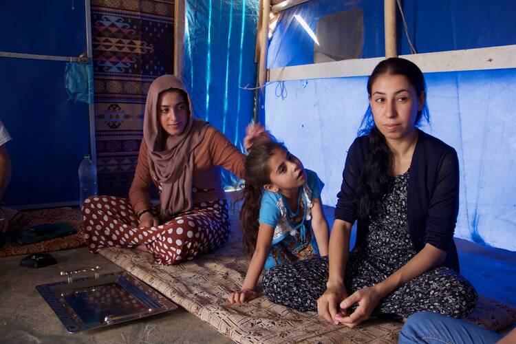 Layla Taalo, far right, with her daughter and niece. All were captives of ISIS. Photo by Kevin Clarke.