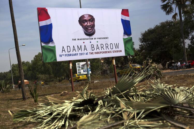 A billboard calling for the inauguration of Adam Barrow as president on Feb. 18 is set on the side of a road in Serrukunda, Gambia, on Jan. 27. Hundreds of thousands turned out on Jan. 26 to greet President Adama Barrow, a week after he took the oath of office in neighboring Senegal. (AP Photo/Jerome Delay)