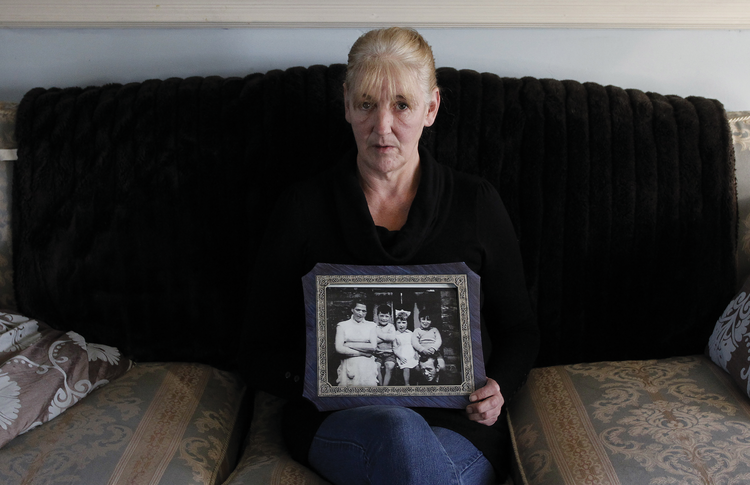 Helen McKendry holds a family photo with her mother, Jean McConville, at home in Killyleagh, Northern Ireland, in 2012 (AP Photo/Peter Morrison).