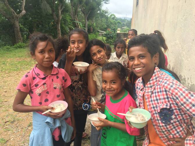 Feeding under nourished village children at Cocoa, East Timor.  Photo by Michael Sainsbury.