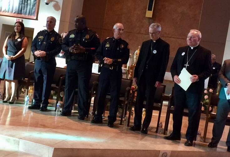 Dallas Auxiliary Bishop Gregory Kelly (left) and Bishop Edward J. Burns (right) meet with local law enforcment during a Dallas Area Interfaith meeting last November. Photo courtesy Dallas Area Interfaith