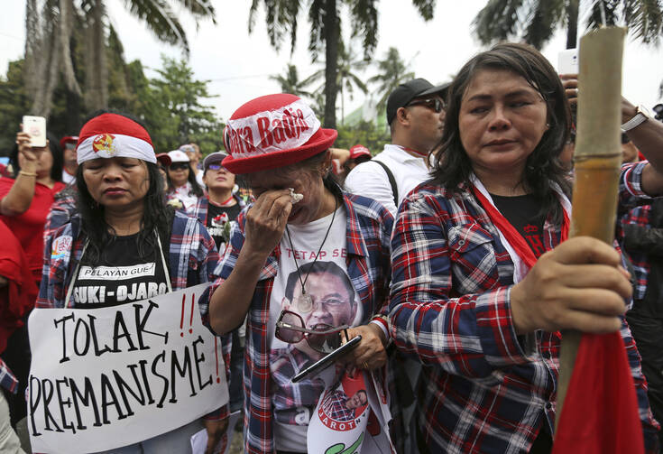 Supporters of Jakarta Governor Basuki "Ahok" Tjahaja Purnama weep as they react to the judges' verdict outside the court where his sentencing hearing is held in Jakarta, Indonesia, on Tuesday, May 9, 2017.  (AP Photo/Dita Alangkara)