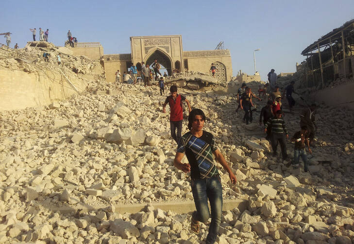 n this Thursday, July 24, 2014 file photo, people walk on the rubble of the destroyed Mosque of The Prophet Younis, or Jonah, in Mosul, 225 miles (360 kilometers) northwest of Baghdad, Iraq.(AP Photo, File)