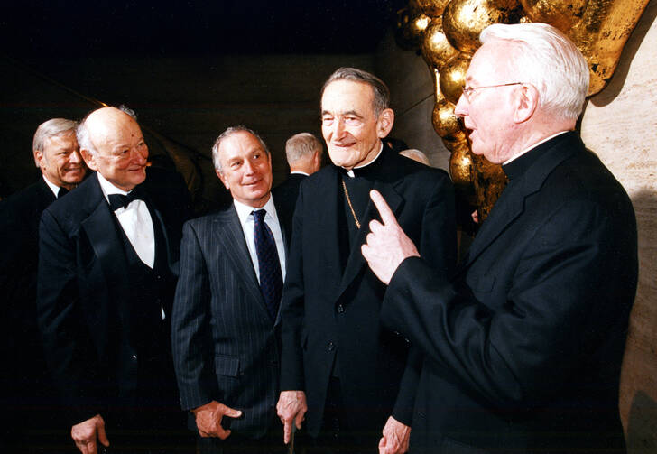 Father O’Hare holds forth with (right to left) Cardinal Avery Dulles and New York Mayors Michael Bloomberg and Ed Koch. Photo courtesy of Fordham University