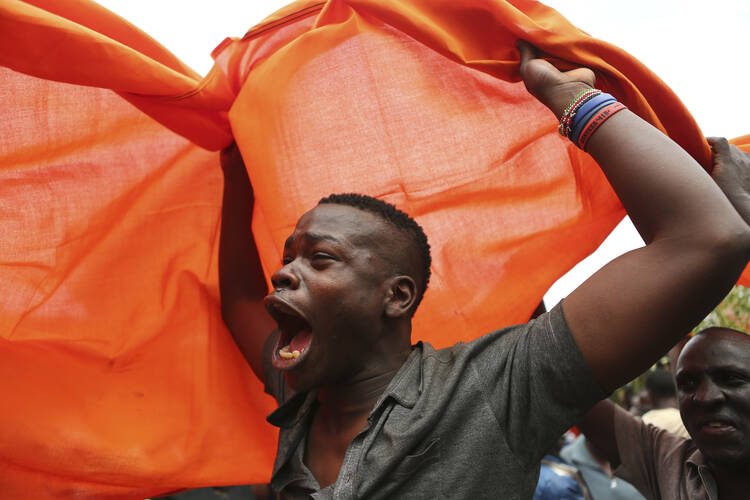 A supporter of opposition leader Raila Odinga celebrates after hearing the decision of Kenya's Supreme Court on Sept. 1 to nullify President Uhuru Kenyatta's election win last month. (AP Photo/Brian Inganga)