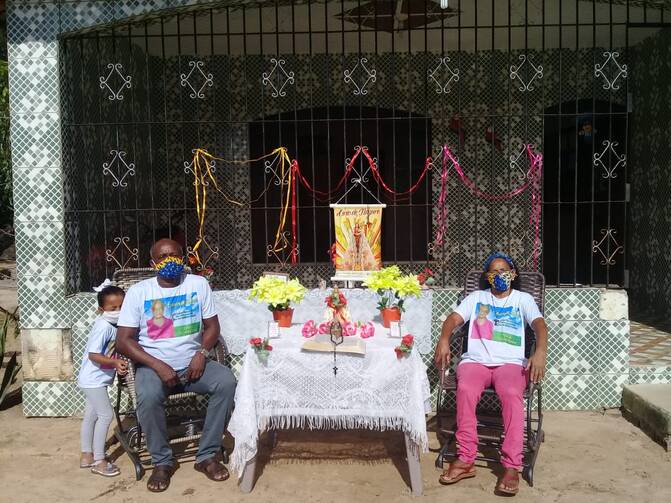 Residents of the quilombola community of Itacoã-Miri, in Pará State, celebrate the festivity of Círio de Santa Maria. The traditional procession was cancelled, so residents stood in front of their homes as a motorcycle circulated with a statue of the Blessed Mother. Photo by Elisa Monteiro.