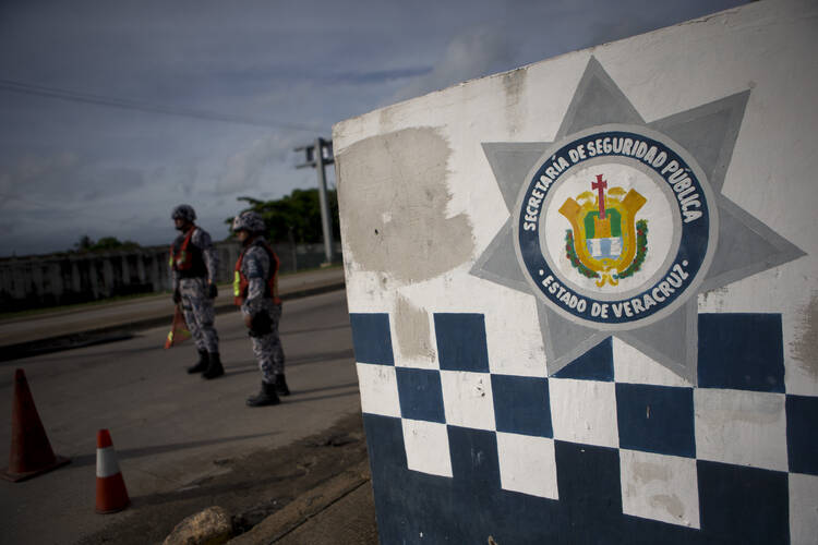 Veracruz state police man a standing roadblock on a highway leaving Coatzacoalcos, Mexico, in July. Despite President Enrique Pena Nieto's promises of a safer nation when he came to power five years ago, the violence is outpacing even the darkest days of the drug war launched by his predecessor. (AP Photo/Rebecca Blackwell)