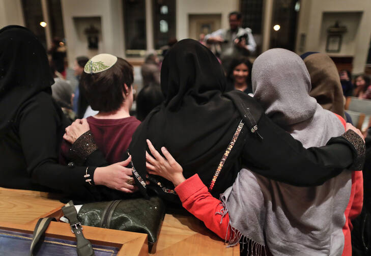 In this Thursday, Feb. 16, 2017 photo, members of the Sisterhood Salaam Shalom, gather for a group photo after a unity vigil held at the Jewish Theological Seminary in New York. (AP Photo/Julie Jacobson)