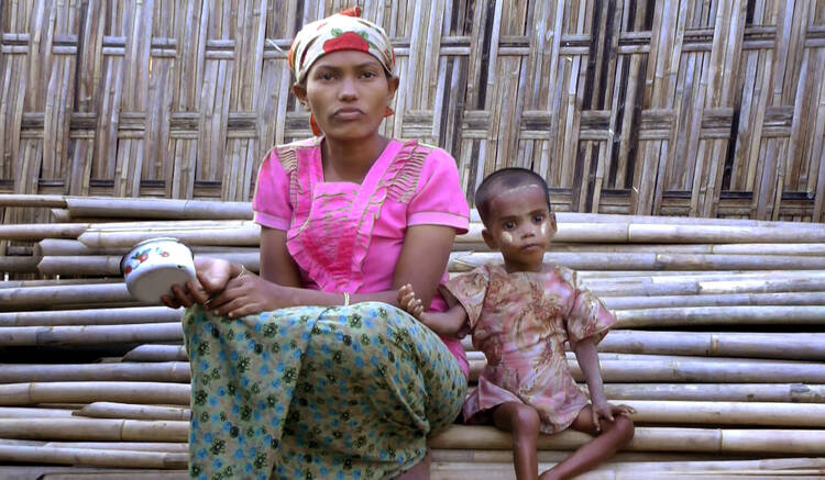 Rosmaida Bibi, right, who suffers from severe malnutrition, sits with her 20-year old mother Hamida Begum outside their makeshift shelter at the Dar Paing camp, north of Sittwe, Rakhine State, Myanmar, in March 2017. Rosmaida Bibi looks a lot like any of the underfed 1-year-olds in a squalid camp for Myanmar's displaced ethnic Rohingya minority—but she's 4. She cannot grow, and her mother can't find anyone to help her because authorities won't let Rohingya leave the camp. (AP Video)