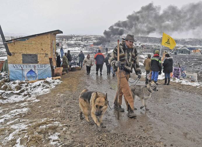 Jasper Spillman, of Lawrence, Kan., joins others departing from the "water protectors" main camp on Feb. 22, 2017, near Cannon Ball, N.D. (Tom Stromme/The Bismarck Tribune via AP)