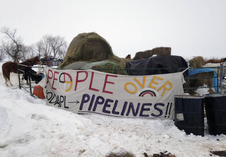 Hay is stacked up to feed horses at a protest encampment along the route of the Dakota Access oil pipeline near Cannon Ball in southern North Dakota on Tuesday, Jan. 24, 2017. President Donald Trump on Tuesday issued an executive action to advance construction of the pipeline, which opponents believe threatens drinking water and cultural sites. The pipeline developer disputes that. (AP Photo/James MacPherson)