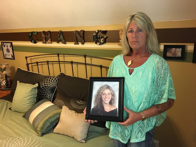 Patty Farrell stands beside a memorial to her daughter in front of her home on Friday, June 16, 2017 in Colonie, N.Y.. Farrell found her daughter, Laree, dead of a heroin overdose in bed four years ago and is now lobbying for a state law setting harsher penalties for drug dealers whose product causes a death. (AP Photo/Mary Esch)