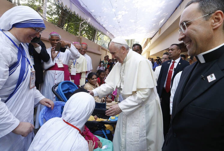 Pope Francis blesses people as he visits the Mother Teresa House
