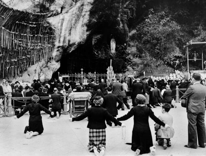 Pilgrims kneeling before shrine of our Lady of Lourdes. Wellcome Images