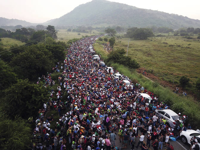 Members of a U.S.-bound migrant caravan stand on a road after federal police briefly blocked their way outside the town of Arriaga, Mexico, on Oct. 27, 2018. (AP Photo/Rodrigo Abd)