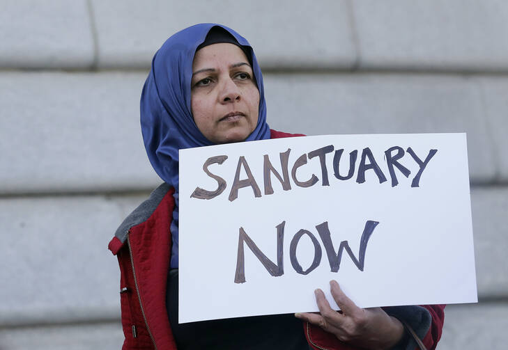 In this Jan. 25, 2017 file photo, Moina Shaiq holds a sign at a rally outside of City Hall in San Francisco. (AP Photo/Jeff Chiu, File)