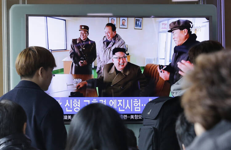 People watch a TV news program showing an image, published in North Korea's Rodong Sinmun newspaper, of North Korean leader Kim Jong Un at the country's Sohae launch site, at Seoul Railway station in Seoul, South Korea, on Sunday, March 19, 2017. (AP Photo/Ahn Young-joon)