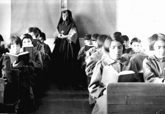Students from Fort Albany Residential School reading in class overseen by a nun, circa 1945. From the Edmund Metatawabin collection at the University of Algoma. (Wikimedia Commons)