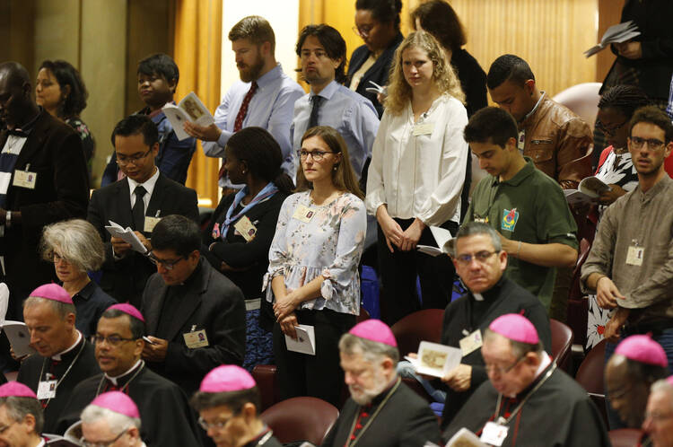 people standing behind bishops in a church area at the vatican