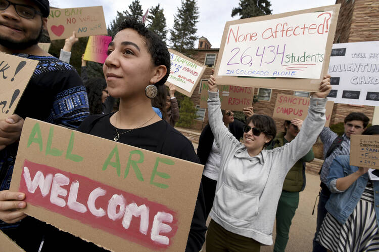 Gwendalynn Roebeke, left, is among dozens of people at a travel ban protest at the University of Colorado in Boulder on Thursday, Feb. 9, 2017. ( Cliff Grassmick/Daily Camera via AP)