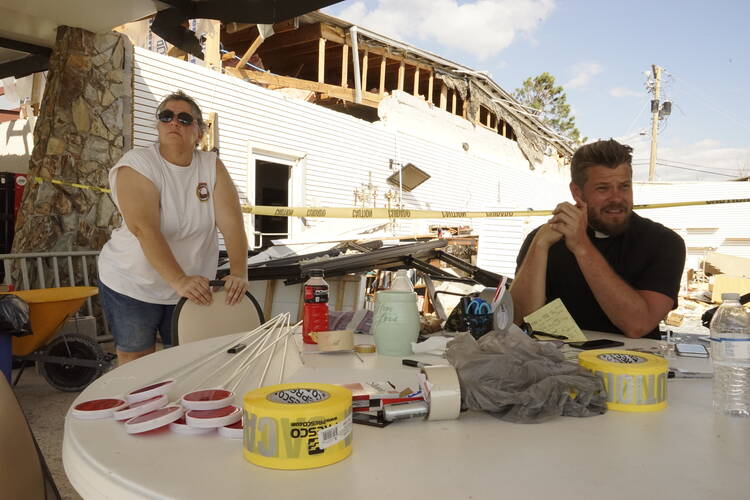 Father Michael Nixon and parishioner work a volunteer table at St. Dominic Catholic Church in Panama City, Fla. Photo by Atena Sherry.