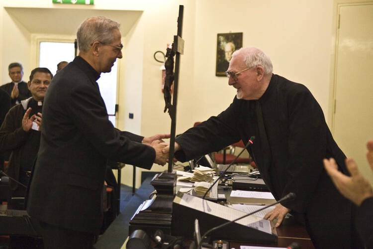 Father Adolfo Nicolas, superior general of the Society of Jesus, greets his predecessor, Father Peter Hans Kolvenbach. (CNS photo/Don Doll, S.J.)