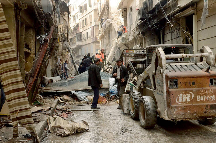 Syrian citizens clear streets in late April after shelling in Aleppo. Chaldean Catholic Bishop Antoine Audo of Aleppo says Christians are losing hope, but not faith, as fighting continues. (CNS photo/Syrian Arab News Agency handout via Reuters)